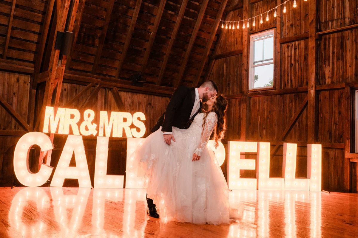 Wedding couple with lit name signs dance floor